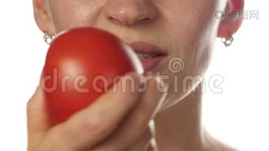 美女嘴吃番茄。 喜欢品尝西红柿的女孩。 健康的食物和节食的概念。 4K视频