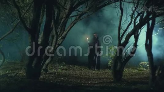 神秘的女孩在黑暗的森林里拿着蜡烛视频