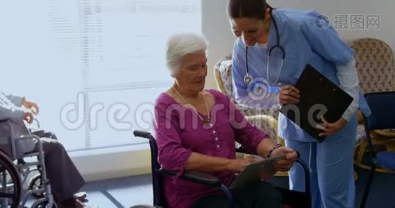 高加索女医生和老年妇女在护理中心讨论数字平板电脑的正面看法视频