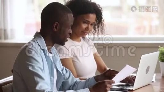 快乐的非裔美国人年轻夫妇在家里网上付账视频