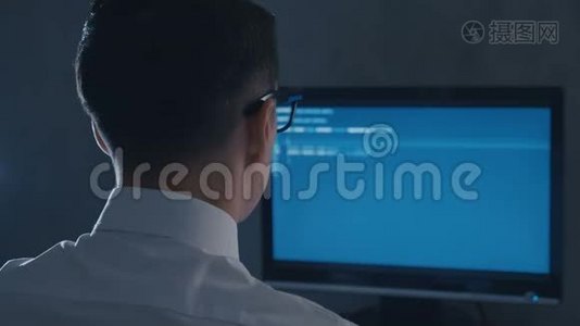夜间办公室电脑显示器眼镜编程专业程序员的后视图视频