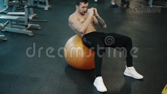 年轻肌肉男用健身球训练腹肌视频