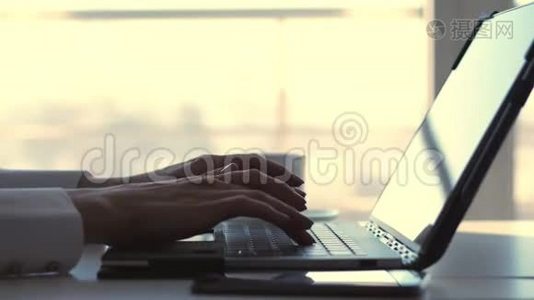 特写，女性手在笔记本电脑键盘上打字。 同时，一位商界女性会在视频