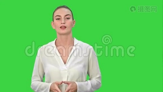 一位年轻的商业女性的肖像，用一只手在绿色屏幕上呈现一些东西，Chroma键。视频