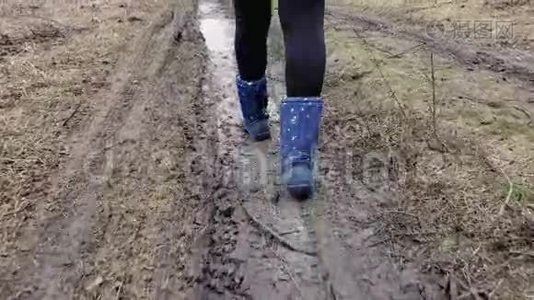 女人的靴子穿过泥泞视频