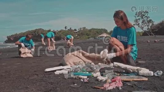 女志愿者清洁海滩使用生态袋，分类塑料在黑色海滩视频