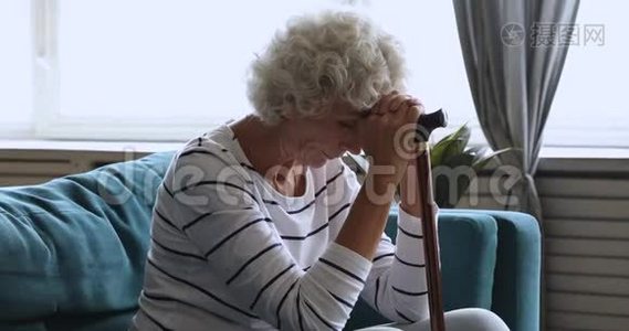 一个孤独的老妇人独自坐在家里拿着拐杖视频