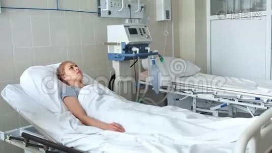 医生站在病床旁与年轻女性病人讨论视频