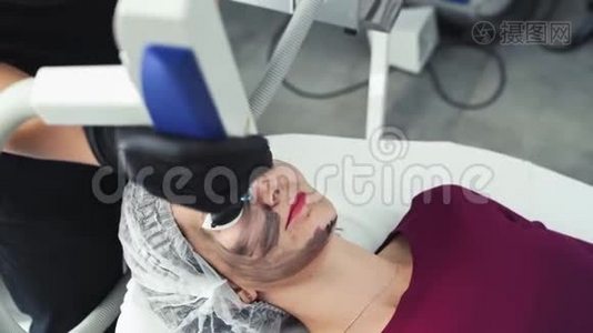 特写美容师做碳剥离手术，激光闪光清洁病人面部皮肤视频