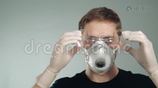 面的防护面罩.. 一个人戴上眼镜。 保护呼吸系统和眼睛。视频