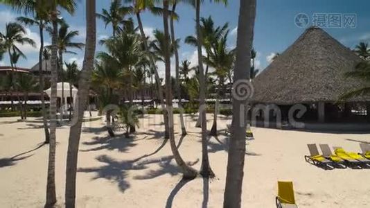 棕榈树，太阳椅，白沙，蓬塔卡纳海滩上的游泳池。 豪华度假胜地。视频