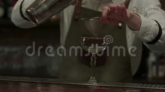 专家酒吧老板把准备好的摇床鸡尾酒倒入玻璃杯中，然后把它放在夜总会的餐巾上视频