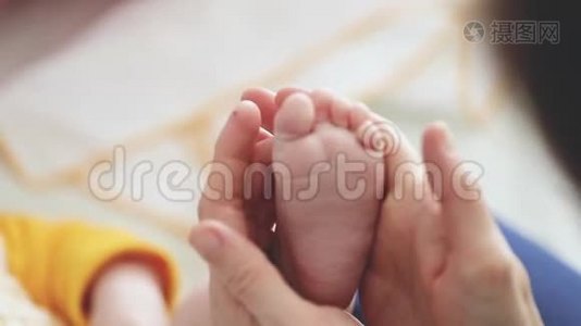 婴儿的脚在母亲的手中。小宝宝的脚放在女性心形的手上特写。妈妈和她的孩子。幸福家庭观。视频
