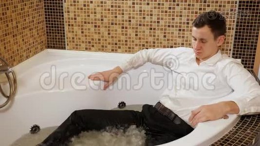 一个穿着衬衫和裤子的男人正在洗澡视频
