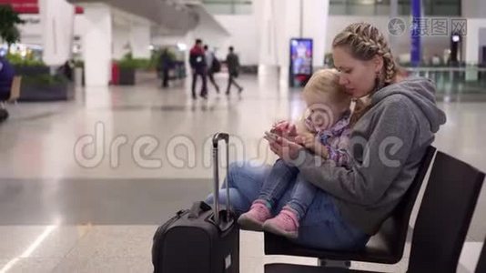 机场候机楼的家人在等待飞机时使用智能手机视频