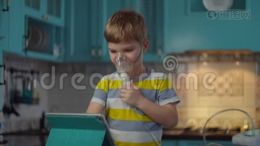 小男孩使用吸入器治疗流感或呼吸道病毒等疾病，并在家看平板电脑。 孩子视频