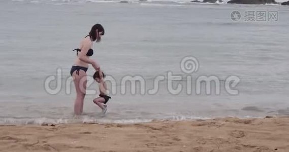 妈妈和小女孩在海滩上玩得很开心。视频