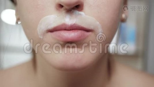 女人剃胡子。 年轻迷人的白种人女孩开着一次性刀片剃胡子视频