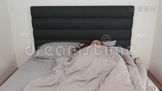 男女睡在灰色的床上。 快乐的成年夫妇躺在卧室里拥抱。 白人女人和男人睡觉视频