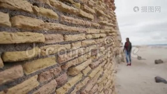 旅游女孩沿着拉迪斯波里的一座古老堡垒的砖墙走视频