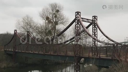 在公园里，一对年轻的夫妇在跨河的桥上奔跑。 早上男女在娱乐区慢跑. 男性视频