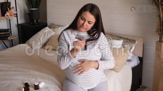 一个怀孕的女孩仔细研究药片上的说明。视频