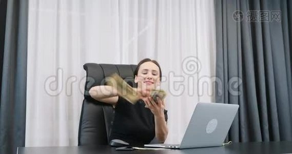 幸福的富婆撒了一大堆钱。 成功的女老板在办公室浪费现金。 女人在空中扔钱视频
