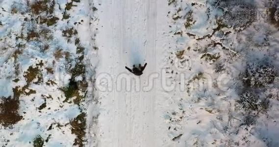 女人在雪地上玩耍的空中镜头视频