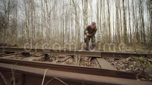 白种人工人在秋天的森林里切换铁路轨道的箭头机构视频