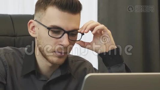 戴着眼镜看着屏幕的男性脸。 自信专注的商人看着笔记本电脑屏幕。 人工画像视频
