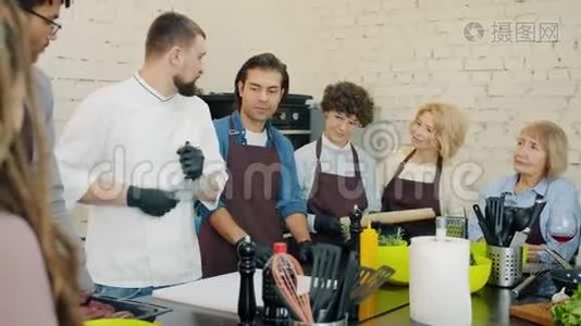 烹饪课学生看厨师磨刀在厨房交谈学习视频