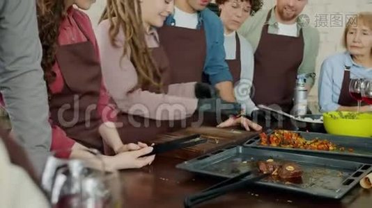 在烹饪大师班期间，快乐的男人和女人在厨房准备美味的菜肴视频