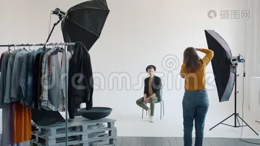 摄影棚摄影后台：男子摆姿势拍照，女子拍照视频