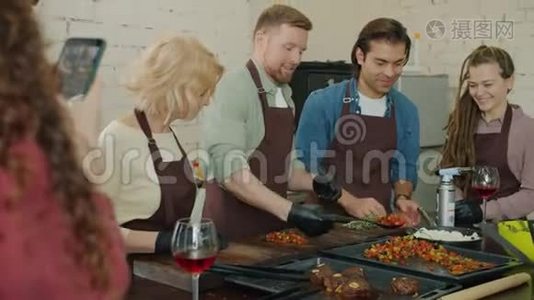 一群厨师一边做饭一边生火做饭，学生用智能手机拍照视频