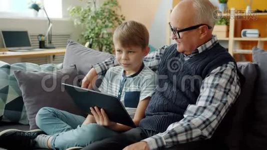 幸福的家庭祖父和孙子在家里用平板电脑聊天视频