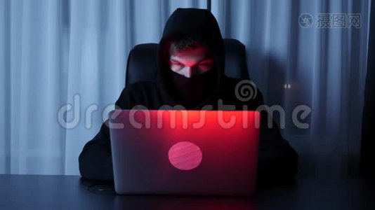 人黑客脸看电脑屏幕.. 男戴黑色口罩和罩破密码和网上社保保障.. H.视频