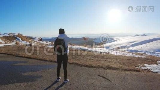 成功的女徒步旅行者在空中张开双臂后，徒步到山顶的云层之上。视频