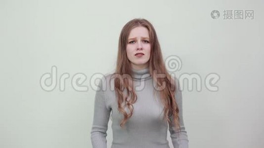 一个年轻漂亮的红发女子穿着灰色毛衣，表情惊恐视频