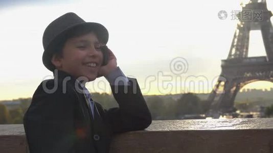 十几岁的男孩正在埃菲尔铁塔的背景上打电话视频
