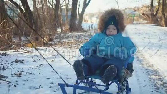 父母在冬天带着快乐的小男孩在雪橇上。 幼儿玩雪橇。 家庭圣诞节的户外乐趣视频