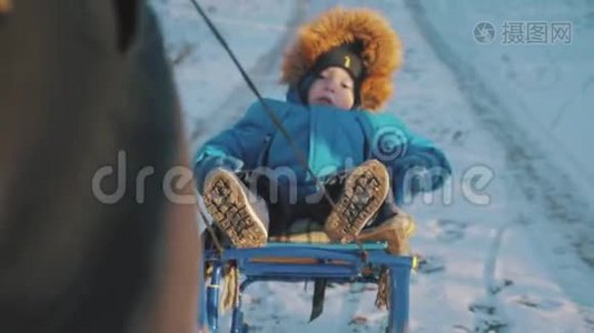 妈妈带着一个孩子坐在雪覆盖的森林上的雪橇上。 开朗的寒假观念..视频