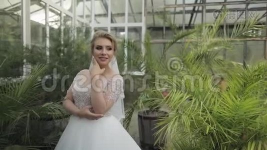 公园里穿着婚纱的美丽可爱的新娘。慢动作视频