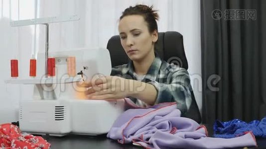 女裁缝在裁缝工作室`缝纫机上缝纫。 女裁缝在做服装。 缝纫面料车间。 创造与泰视频