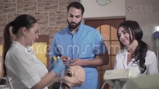 年轻的高加索妇女和中东男子使用设备操纵牙科人体模型视频