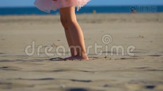 穿粉色裙子的小女孩正在海滩上散步视频