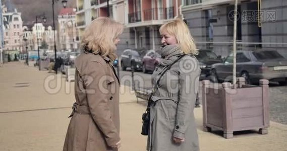 在阳光明媚的秋日，两位开朗的高级女性在城市街道上交谈。 领取养恤金的白种人正退休视频