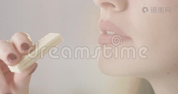 漂亮的女性吃脆皮香草华夫饼干享受美味的甜点，口红和指甲的特写视频