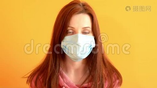 戴医用口罩的女孩用手机说话，黄墙，冠状病毒的流行视频