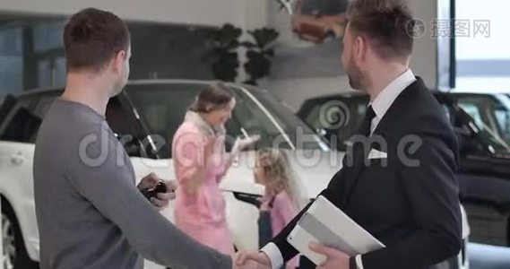 快乐的白人小女孩从后台跑到父亲买新汽车和拿汽车钥匙。 成功视频