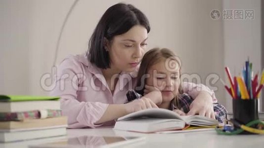 聪明的白种人女孩为妈妈读书的肖像。 可爱的学童和母亲一起做作业。 家长帮助视频